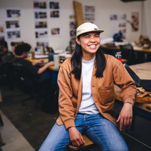  Ho‘o Hee sitting at a table in her studio.