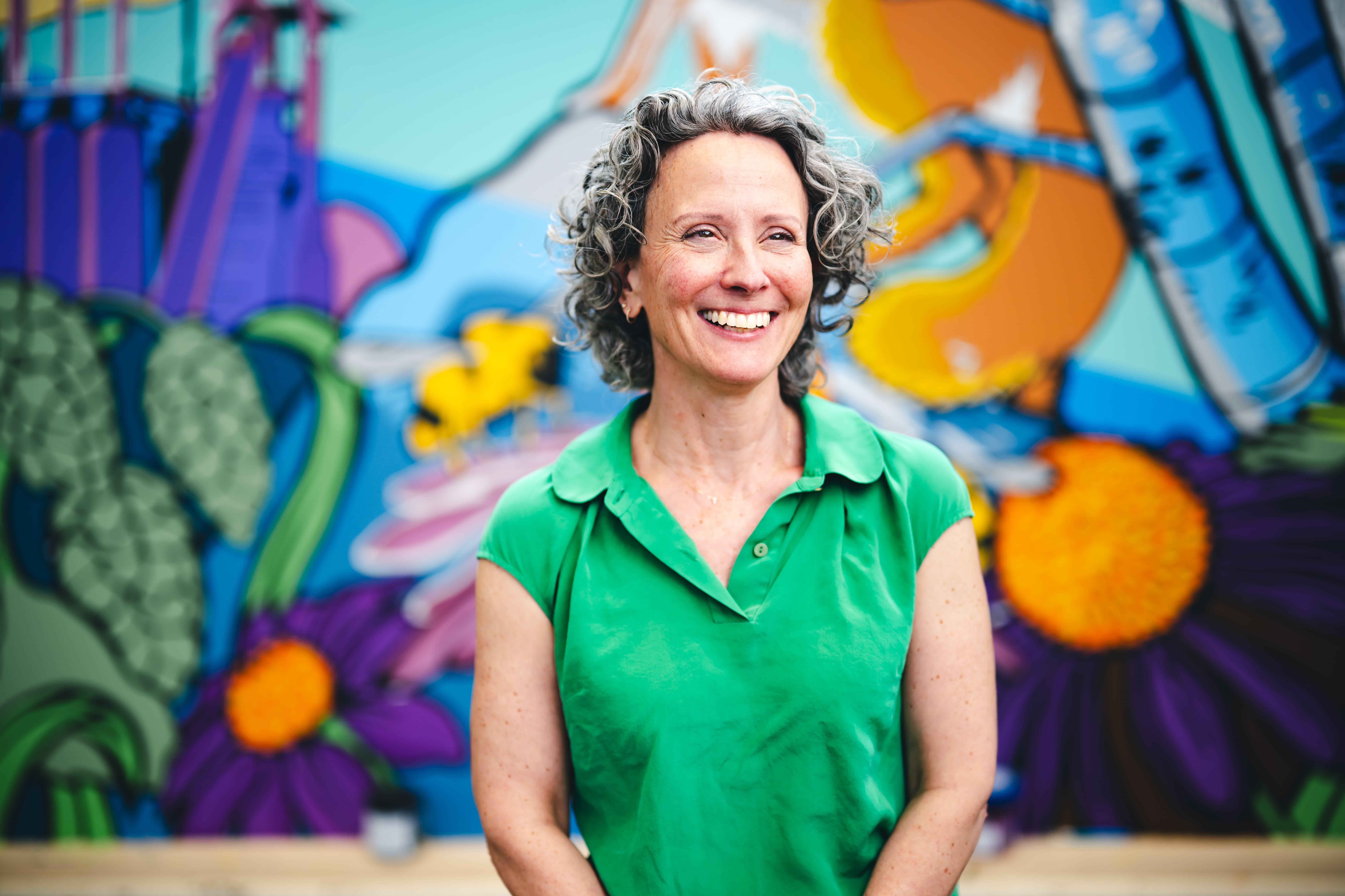 Deirdre Murphy smiling in front of her mural.