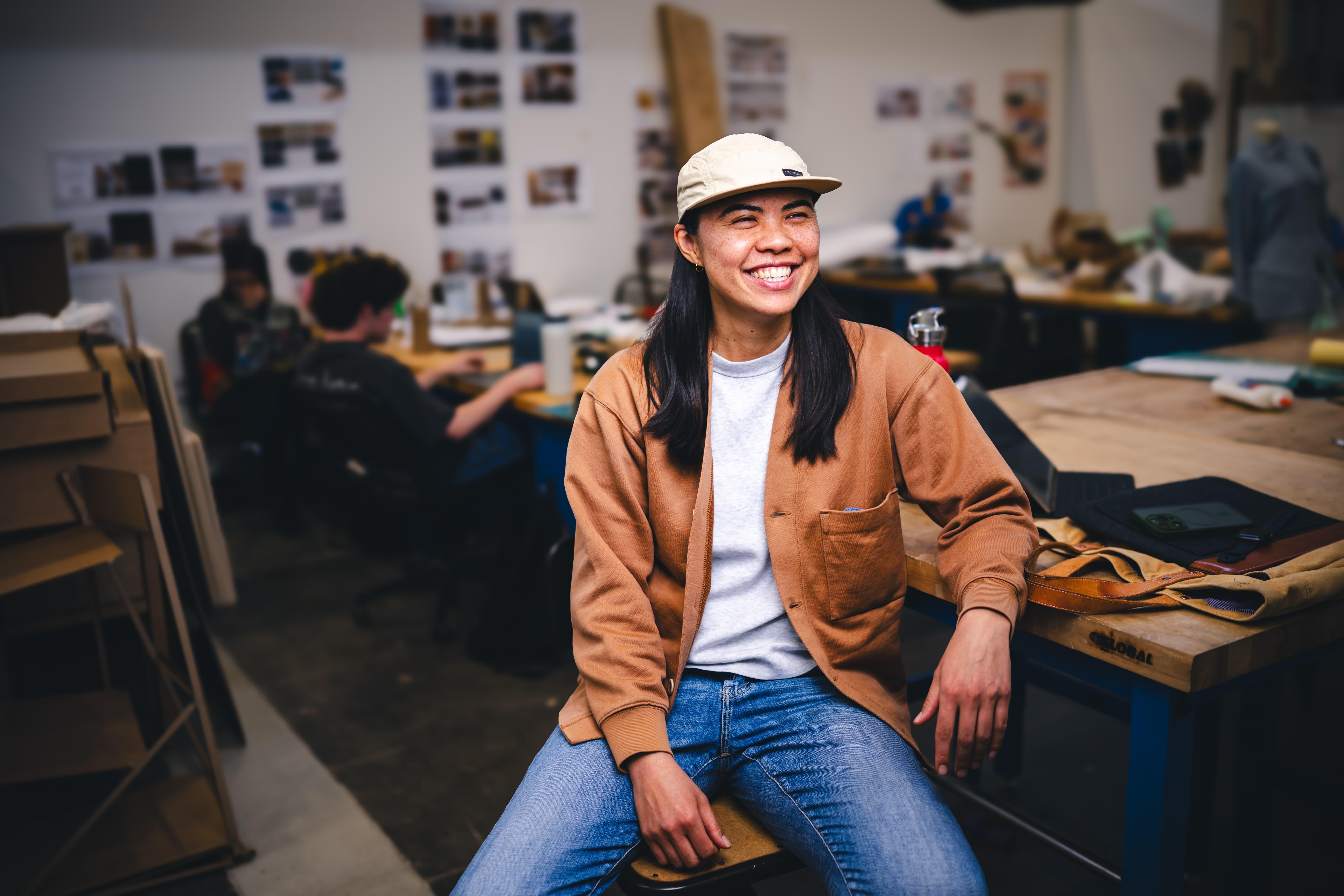  Ho‘o Hee sitting at a table in her studio.