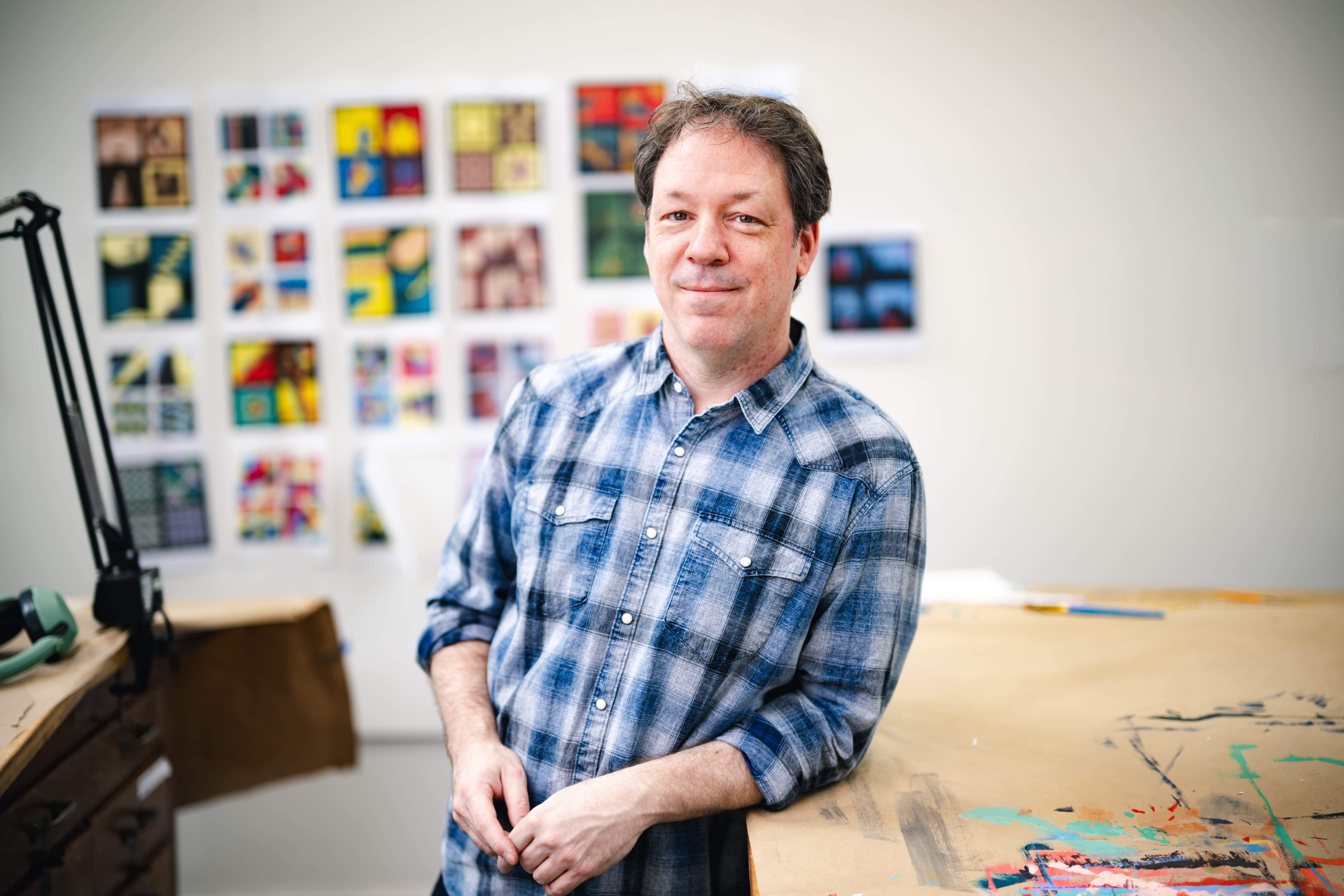 Jason Travers leaning on a table in his studio.