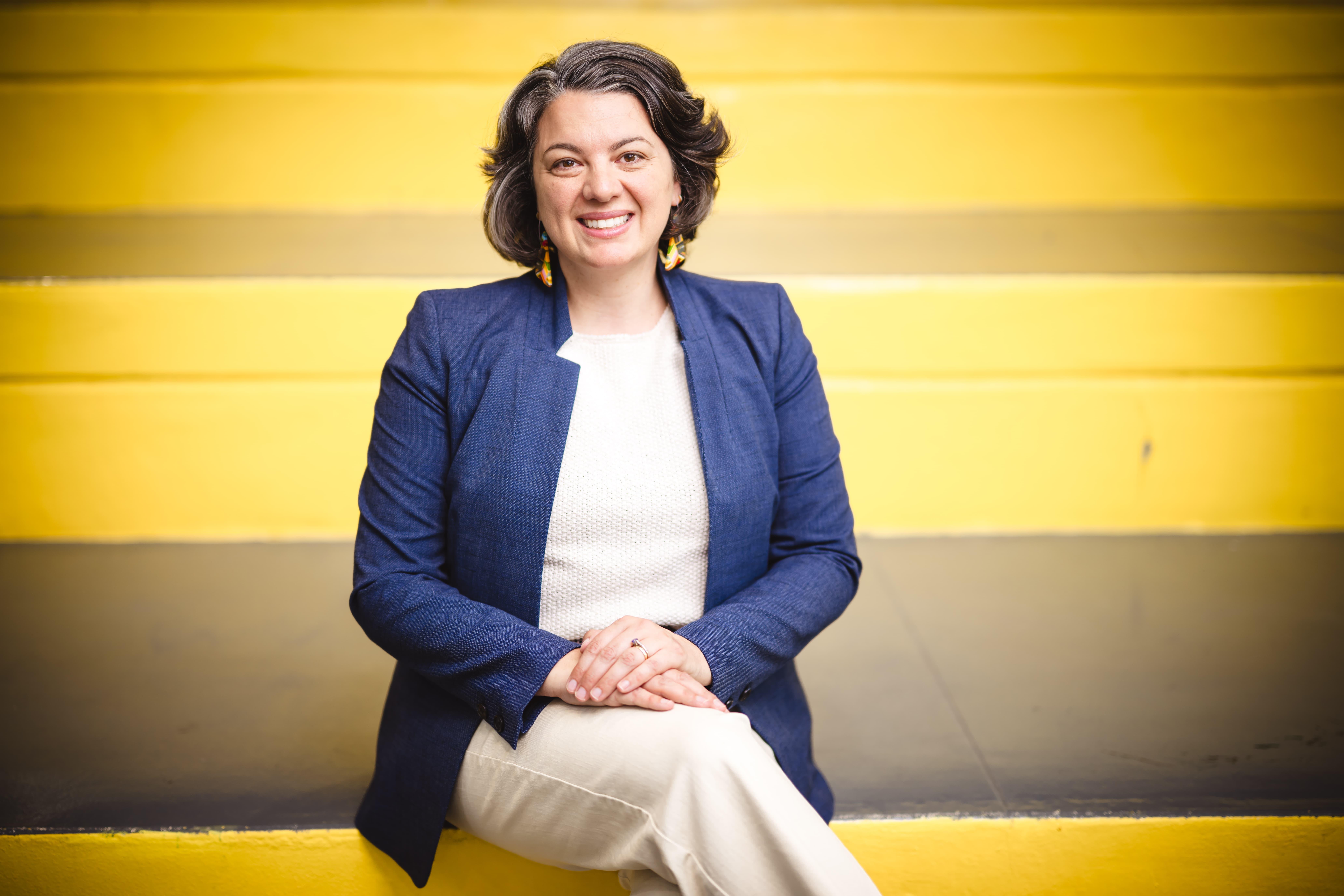 Kateleen Casciano sitting on yellow stairs.