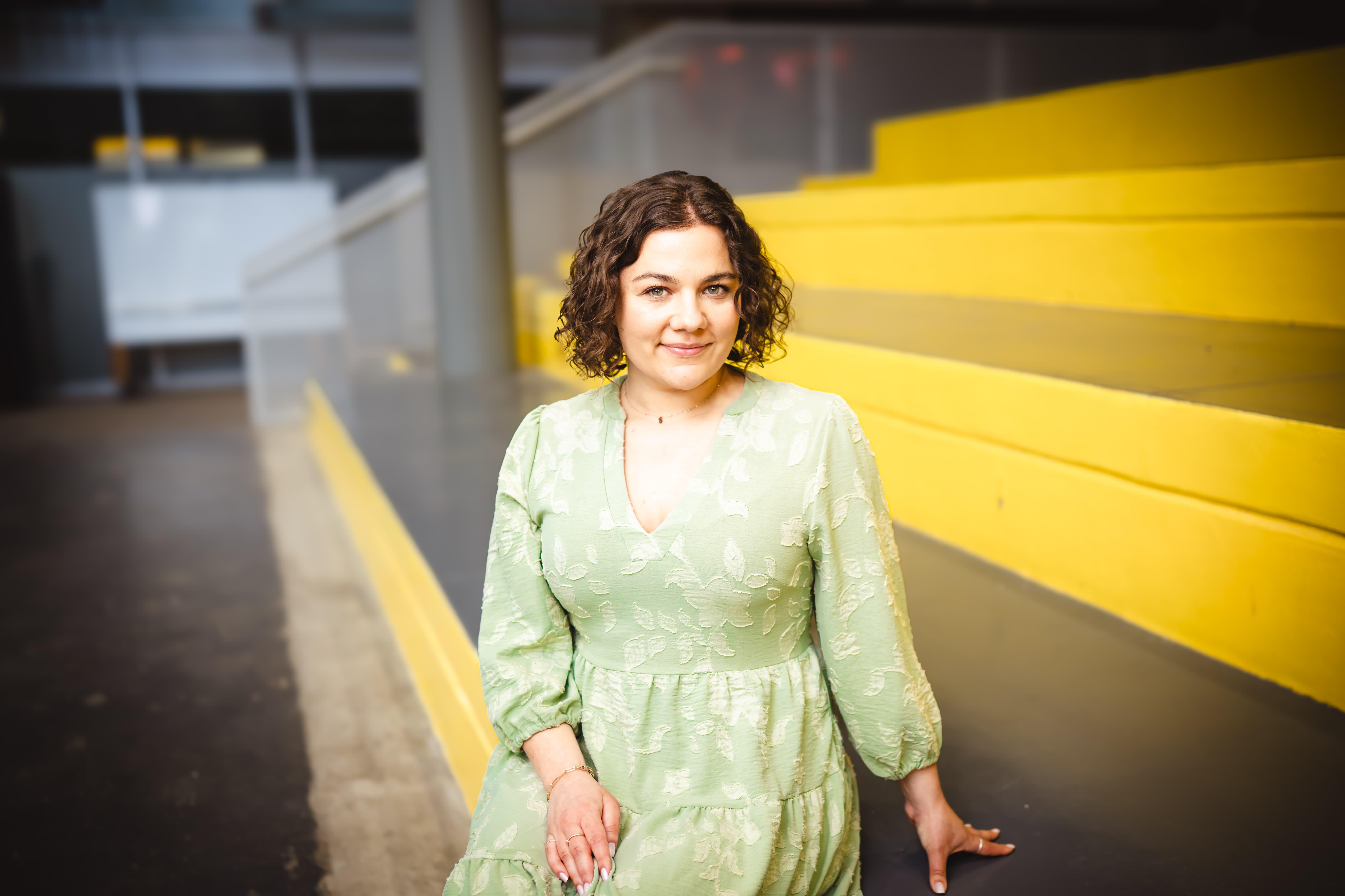 Katie Fritz sitting on yellow stairs.