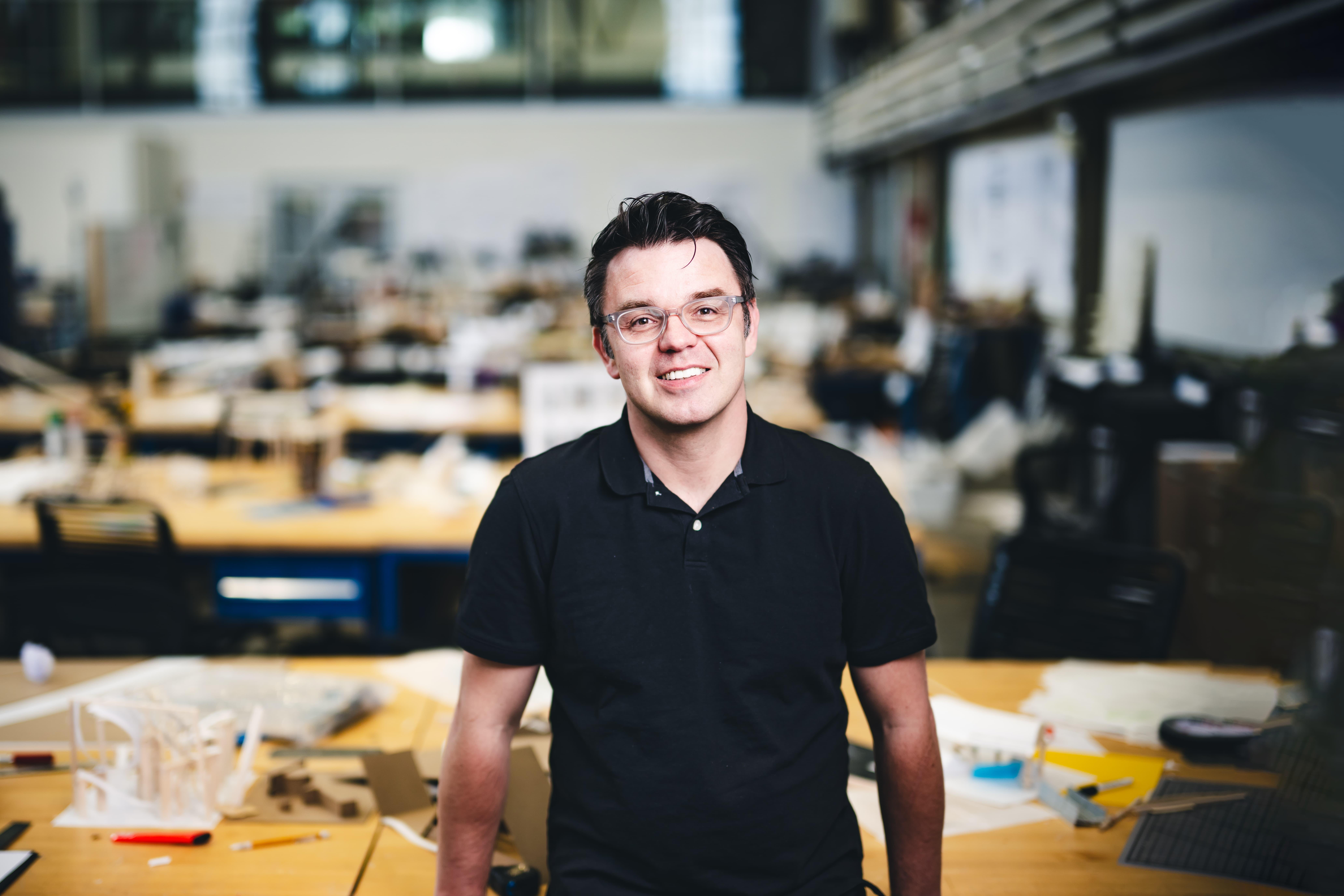 Nik Nikolov leaning on a table in his studio.