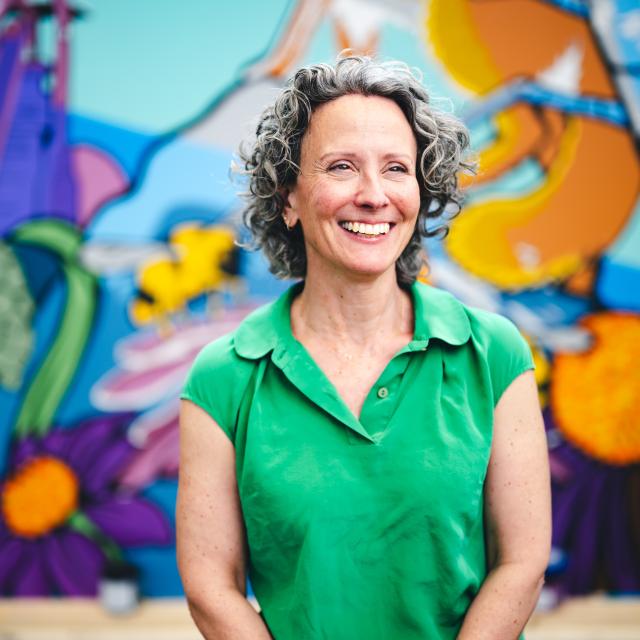 Deirdre Murphy smiling in front of her mural.