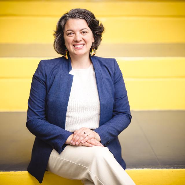 Kateleen Casciano sitting on yellow stairs.