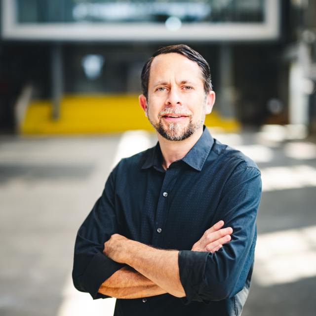 Nick Sawicki standing in a building with his arms folded.