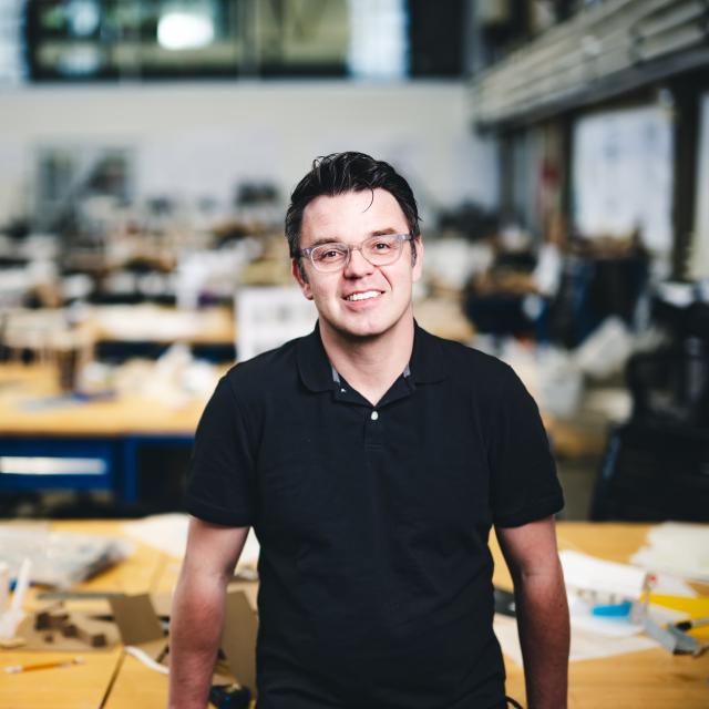 Nik Nikolov leaning on a table in his studio.
