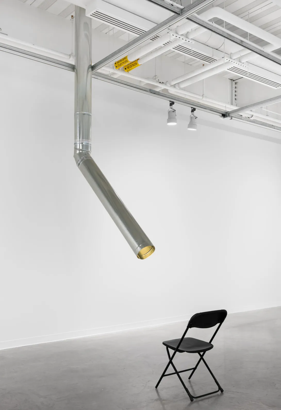 Mallory Kimmel's Repackaging Reality: The Sensation of Sunshine on Your Face, is a ceiling-mounted sculptural lamp with a heat light bulb