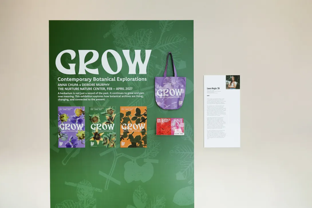 Image of gallery space showing small scale title wall wallpaper labeled Grow, a poster series, totebag, postcards in a brochure holder, and an artist statement plaque.