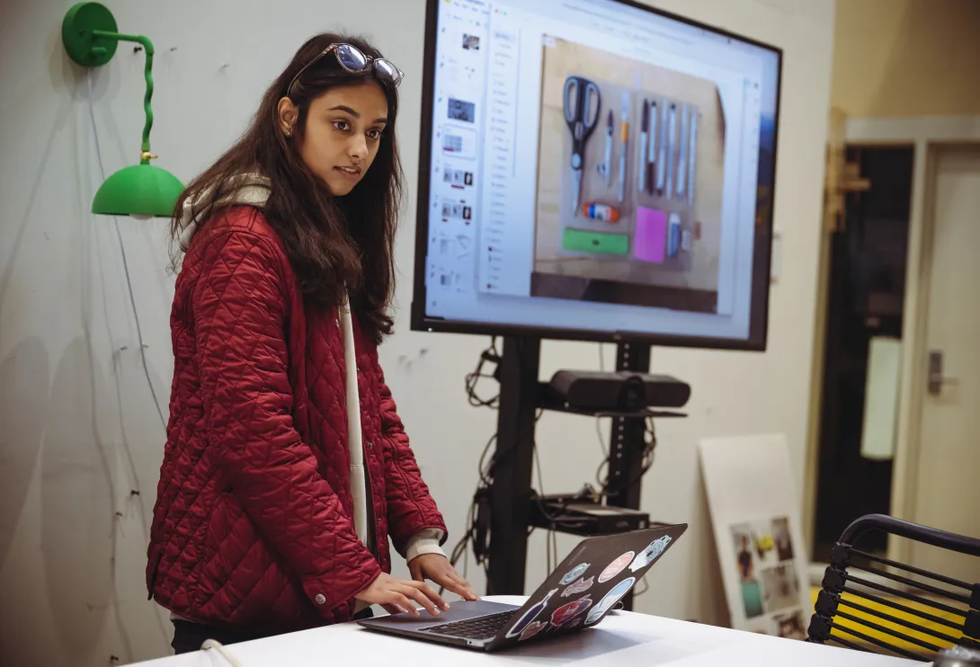 Student presenting her design work on a digital display