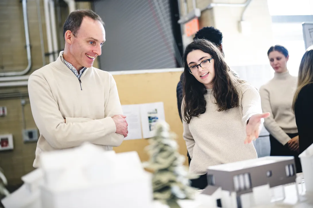 Student presenting an architectural model to an industry research partner