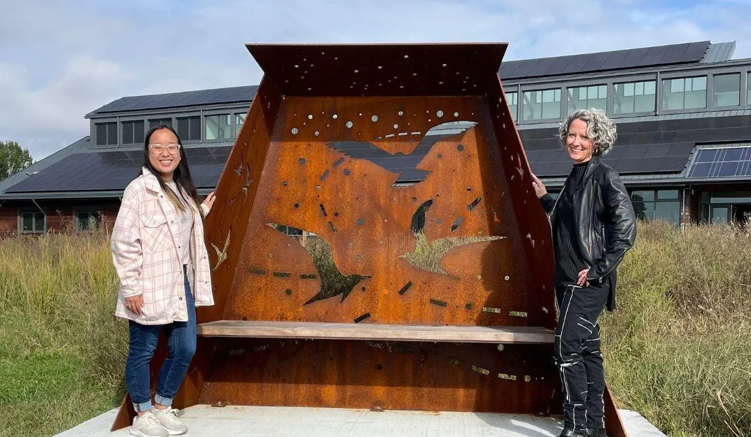 Katie Bui ’26 and Deirdre Murphy celebrate World Migratory Bird Day at Washington College in Maryland, standing by their public art commission, Flyways.